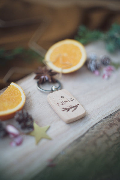 Schlüsselanhänger aus Holz mit Tannenzweig und Wunschname